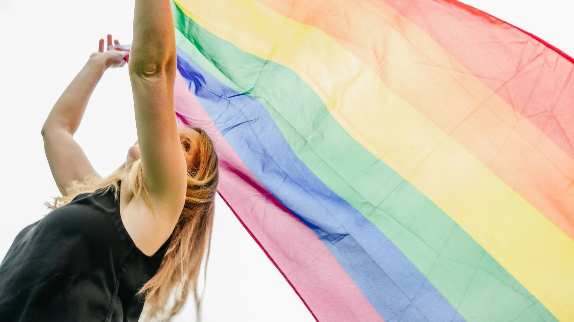 Woman with rainbow flag outdoors
